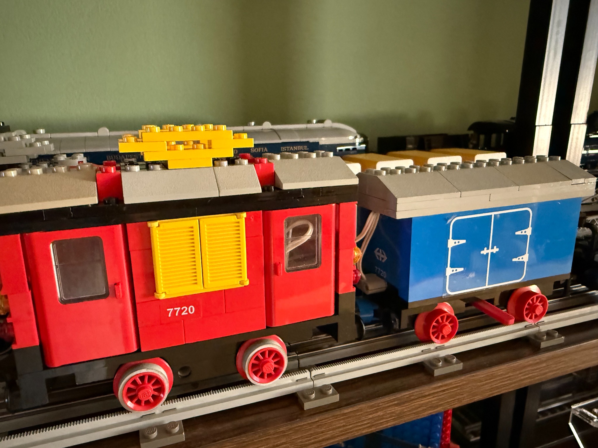 Locomotiva LEGO 7720 con vagone merci blu su binari grigi